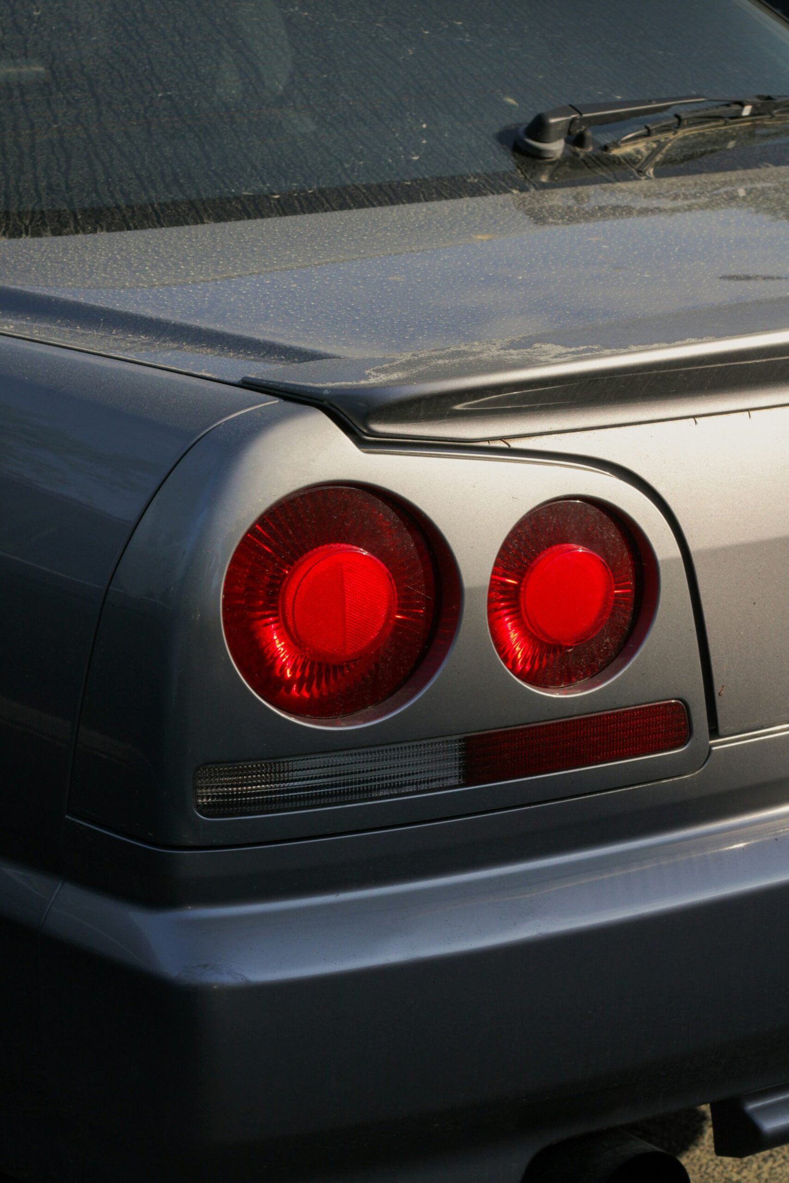 the tail lights of a silver sports car